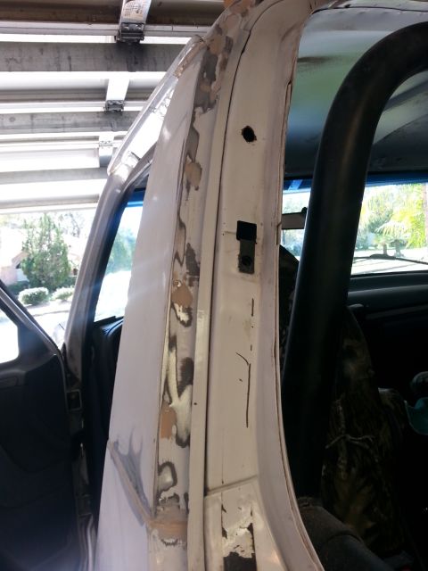 1992 Ford Bronco - Body work in progress on a vehicle's door frame, showing areas of rust and filler application.