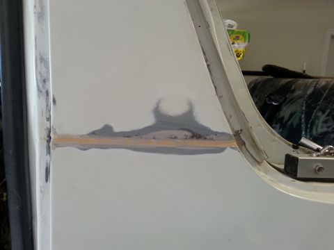 1992 Ford Bronco - Auto body repair work in progress on a vehicle panel, showing primer and filler.