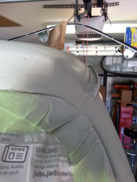 1992 Ford Bronco - A vehicle body panel is covered in masking tape and newspaper, indicating repair work is in progress.