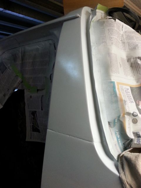 1992 Ford Bronco - Vehicle body panel covered in newspaper and tape, undergoing preparation for repair or painting.