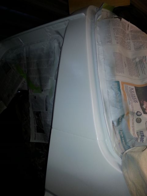 1992 Ford Bronco - Newspaper is used to mask off a vehicle's body panel during a paint job.