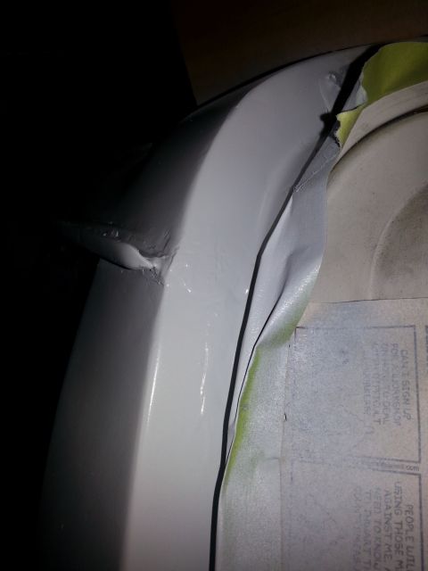 1992 Ford Bronco - Detail of body panel repair, showing masking tape and primer on a vehicle part.