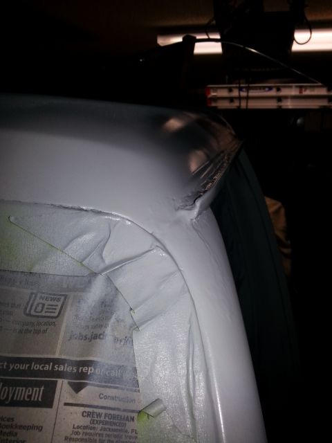1992 Ford Bronco - Newspaper is used to mask off a vehicle body panel during repair work.