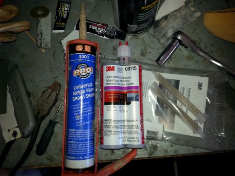1992 Ford Bronco - Automotive repair supplies including sealants and adhesives are laid out on a workbench.