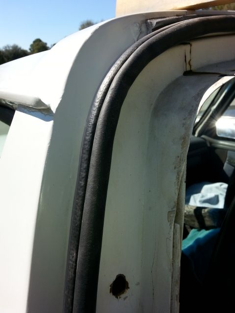 1992 Ford Bronco - Close-up of the door frame seal on a white 1992 Ford Bronco, showing areas of rust repair.