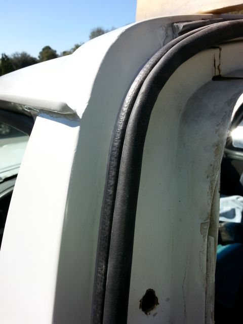 1992 Ford Bronco - Detail of a vehicle's door seal and surrounding bodywork.