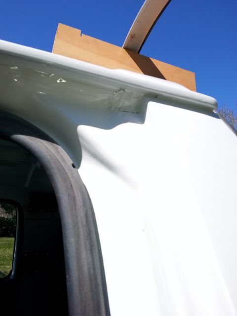 1992 Ford Bronco - Detail of a white vehicle's bodywork, showing a wooden support structure near the roof drip rail.