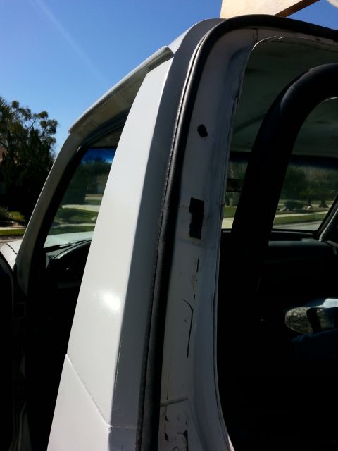 1992 Ford Bronco - Detail shot of the door frame and interior of a vehicle, focusing on the weather stripping and surrounding metal.