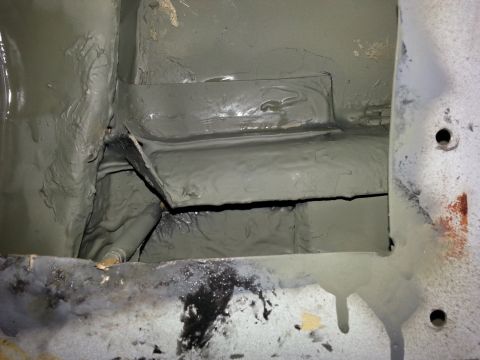 1992 Ford Bronco - Close-up view of underbody chassis repair, showing sealant application and structural components.