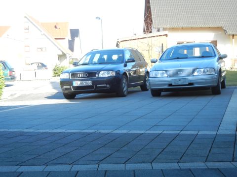 1999 Ford Fairlane - Two station wagons, an Audi and a silver sedan, are parked on a paved driveway.