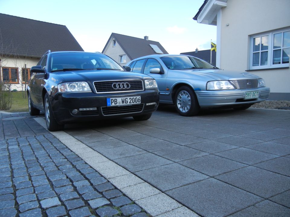 Silver Ford sedan parked next to a black Audi wagon