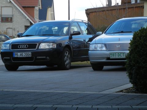 1999 Ford Fairlane - Two cars are parked in front of houses. The Audi has a license plate from 2006.