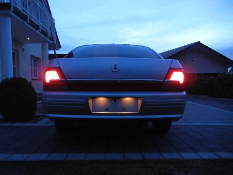 1999 Ford Fairlane - Rear view of a 1999 Ford Fairlane sedan at dusk, showing illuminated taillights.