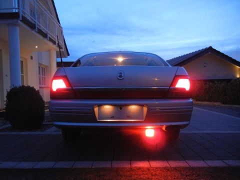 1999 Ford Fairlane - Rear view of a 1999 Ford Fairlane at dusk, showing illuminated brake lights.