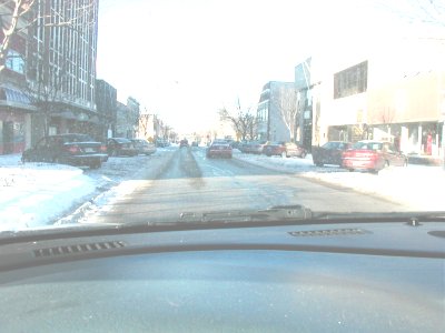 1997 Ford Taurus - Street view from a vehicle's dashboard during winter conditions with snow on the ground.