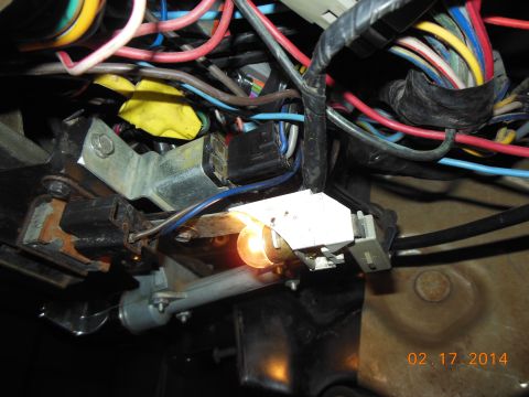 1979 Ford F-150 - A close-up view of a vehicle's complex wiring harness, showing a lit bulb and various connectors.