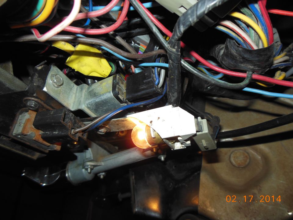 Close-up of a vehicle's wiring harness with a lit bulb