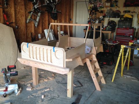 2005 Jeep Wrangler - A wooden bed frame designed to resemble a Jeep Wrangler is shown during its construction phase in a garage.