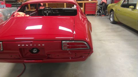 1972 Pontiac Trans Am - A red Pontiac Firebird is shown in a garage, with another car visible to the right. The car appears to be undergoing restoration.