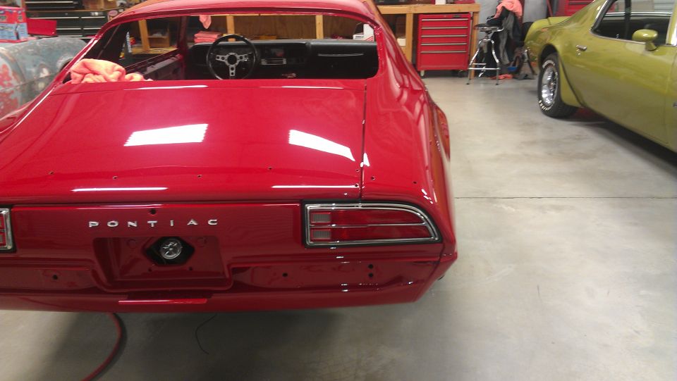 Red Pontiac Firebird rear view, showing 'PONTIAC' badging and taillights