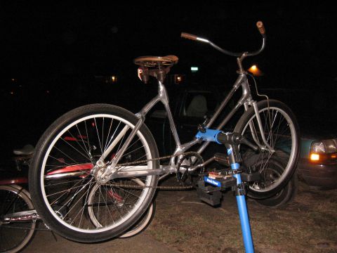 Chrome bicycle on blue repair stand, rear wheel prominent