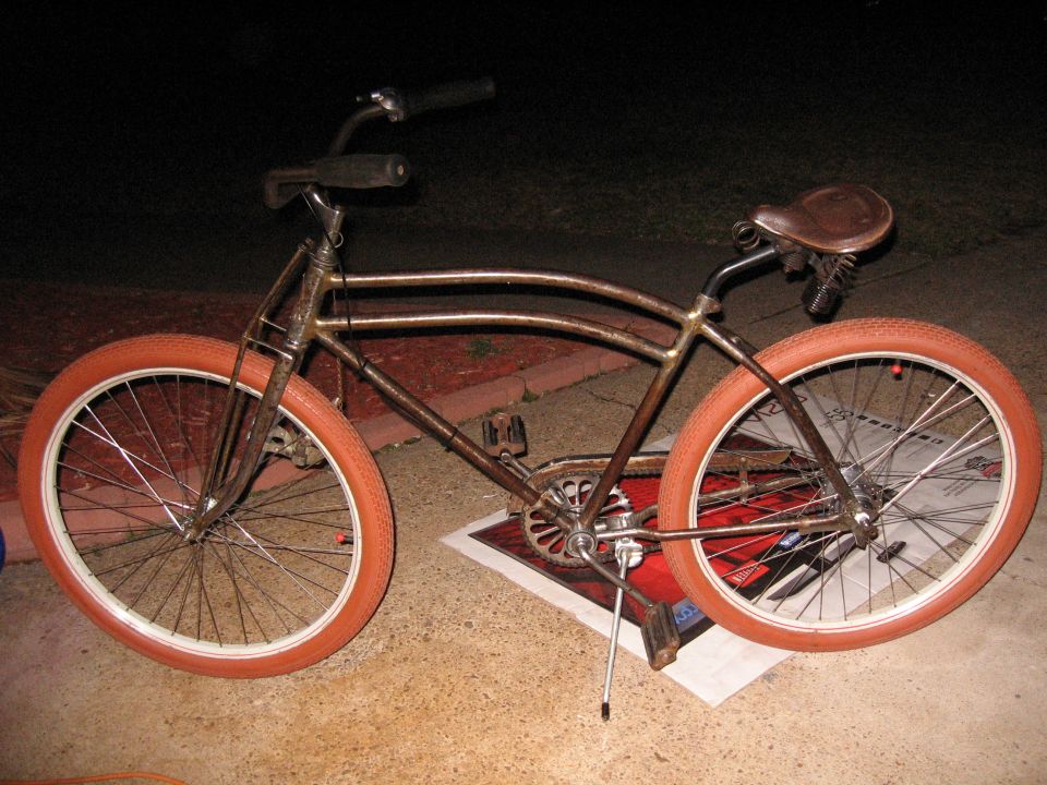 Old cruiser bike with orange tires and a brown leather seat