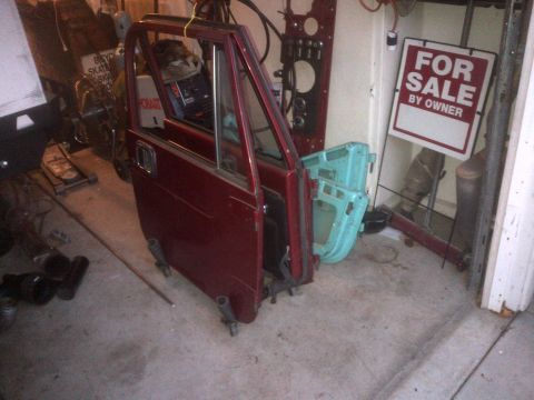 1985 Jeep CJ7 - Two Jeep CJ doors, one red and one blue, are stored in a garage next to a 'For Sale By Owner' sign.