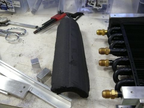 1976 Chevrolet Corvette - Workbench with radiator, insulation, and tools. The radiator has brass fittings and black tubing.