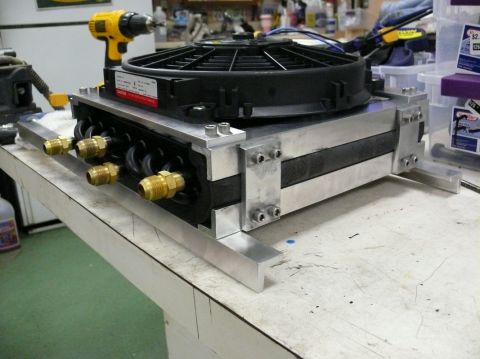 1976 Chevrolet Corvette - An aftermarket oil cooler assembly with an electric fan is shown, likely for a performance vehicle.