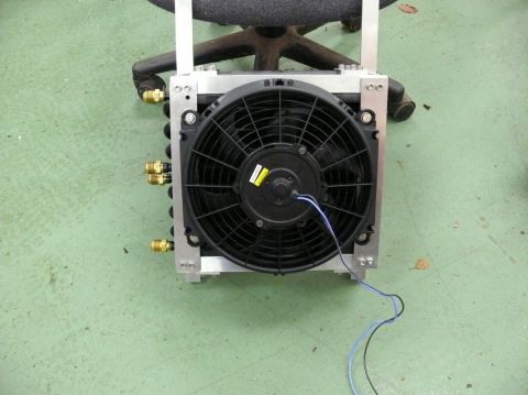 Radiator fan assembly with aluminum frame and brass fittings, mounted on a chair base