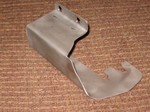 Metal bracket with a hook, resting on a textured surface