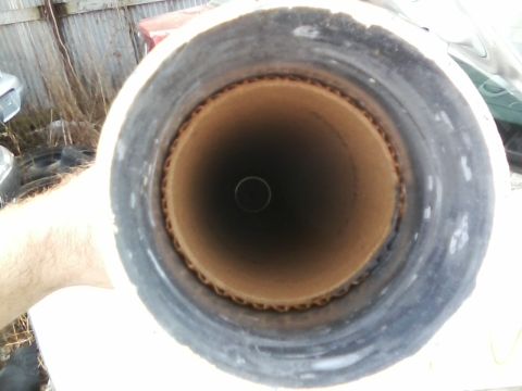 1999 Mercury Grand Marquis - A cardboard tube with a dark interior is shown, with some vehicle parts in the background.