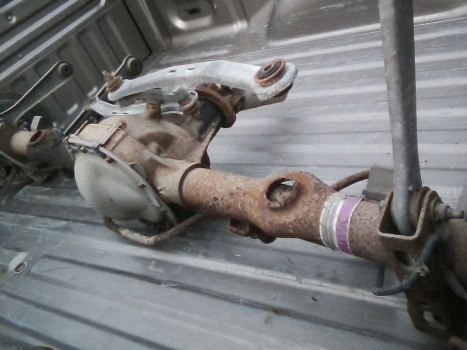 Rear axle assembly with suspension components, resting in a truck bed
