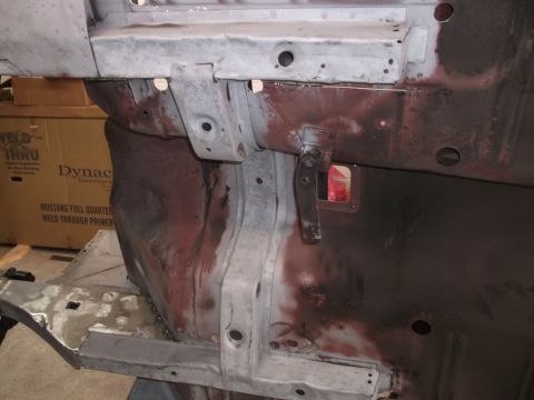 1967 Ford Mustang - Close-up view of a car's structural frame, showing areas of rust and primer application.