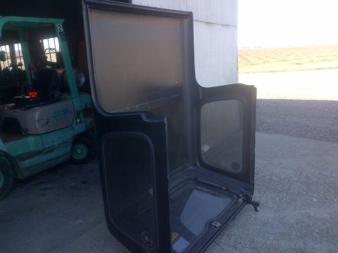 1985 Jeep CJ7 - A black Jeep CJ hardtop is shown with a forklift in the background.