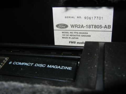 1999 Ford Fairlane - Close-up of a Ford 6-disc compact disc magazine and an FMS audio label with model and serial numbers.