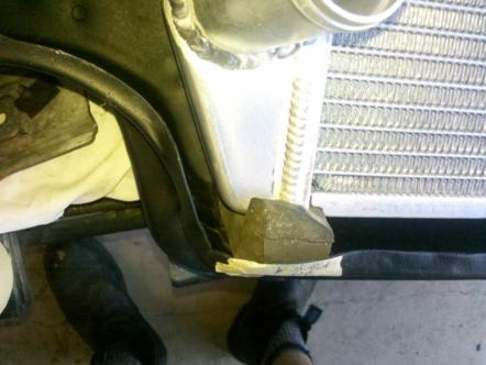 1982 Ford Bronco - Close-up of a radiator mounting bracket, showing its rubber isolator and metal support structure.