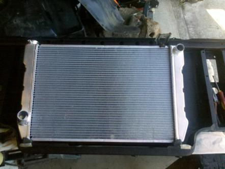 1982 Ford Bronco - A new radiator is installed in the front of a vehicle, likely for an engine repair or upgrade.