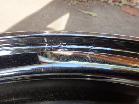 1993 Ford Taurus - A close-up view shows the edge of a shiny chrome wheel rim with some imperfections.