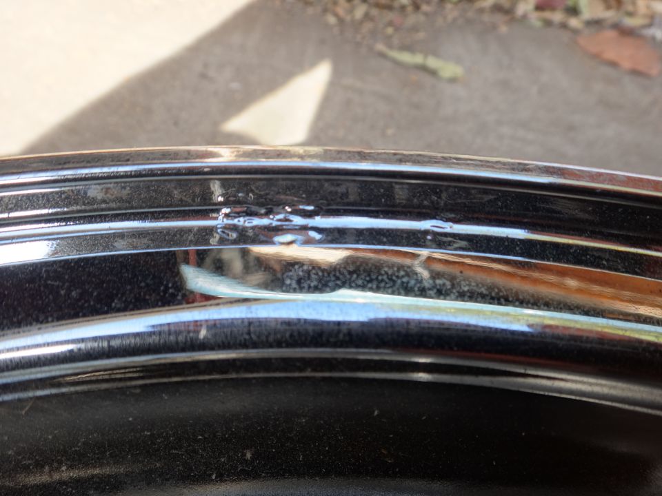 Close-up of a chrome wheel rim with some minor damage