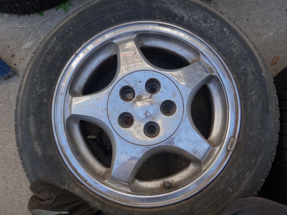 Wheel with five spokes and tire, showing wear and dirt