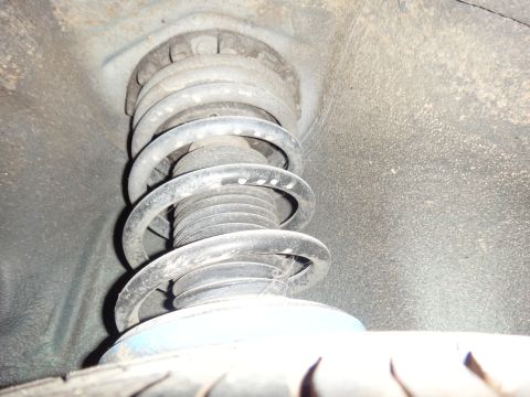 1993 Ford Taurus - Close-up view of a vehicle's front suspension strut and coil spring assembly.
