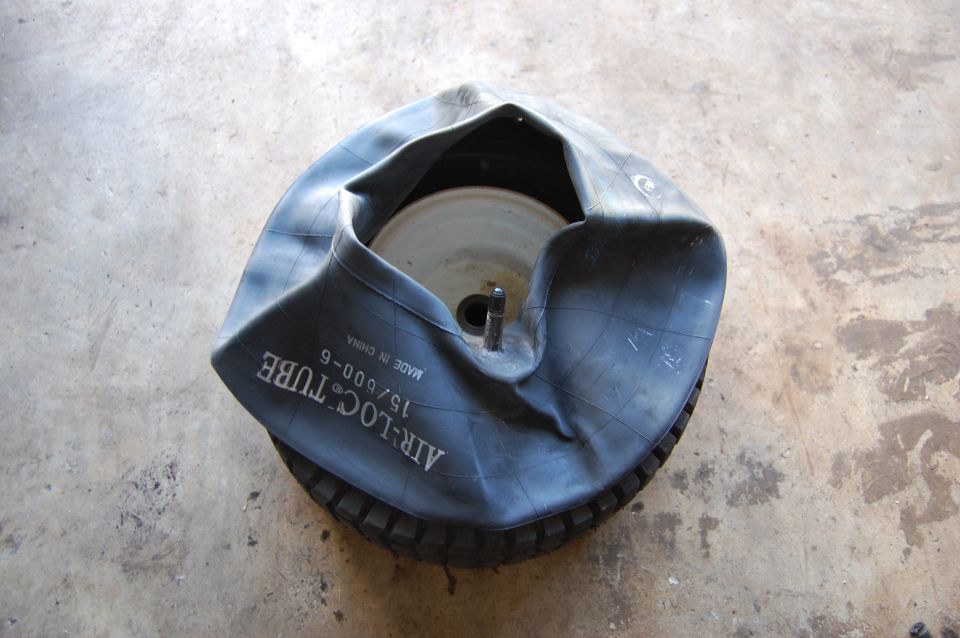 Deflated tire inner tube with text 'AIR-LOC TUBE 15/600-6' visible, lying on a tire