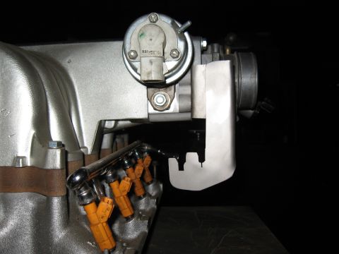 1994 Ford Bronco - A close-up view of fuel injectors and a throttle body assembly, likely from an engine.
