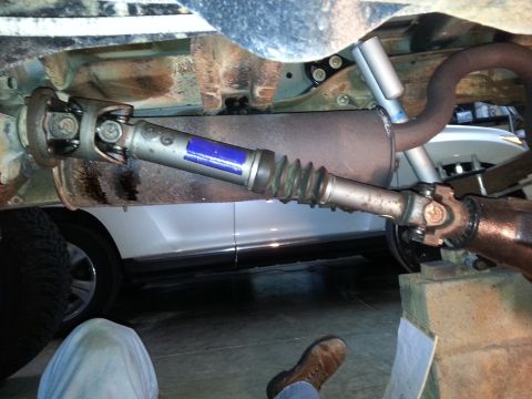 1995 Ford Bronco - Close-up view of a vehicle's undercarriage, focusing on the driveshaft and exhaust system.