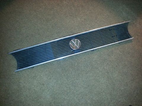 2002 Volkswagen Jetta - A detached Volkswagen grille with the circular emblem is shown against a textured background.