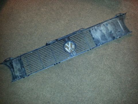 2002 Volkswagen Jetta - A dark Volkswagen grille with the emblem is shown from a top-down perspective on a carpeted floor.