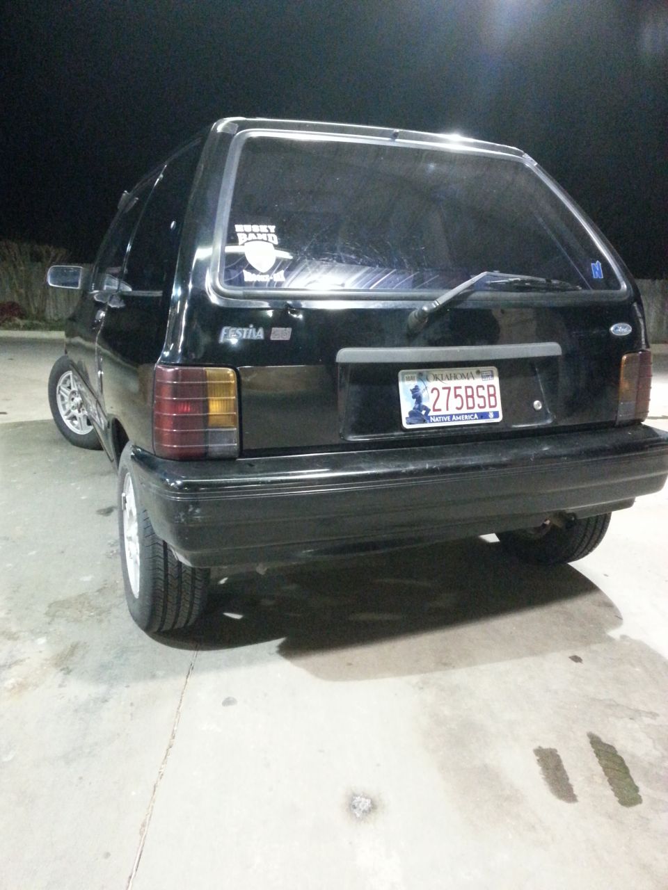 Black 1991 Ford Festiva hatchback, rear view, with a license plate reading 275BSB