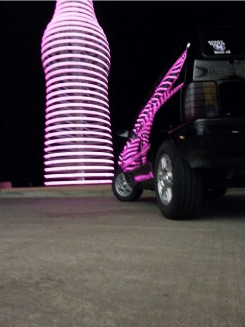 1991 Ford Festiva - A black SUV is seen next to a large pink object in this photograph.