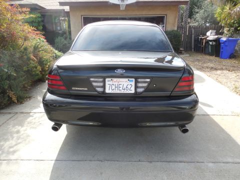 2007 Ford Crown Victoria - This black Ford Crown Victoria Police Interceptor is parked in front of a house with a basketball hoop visible.